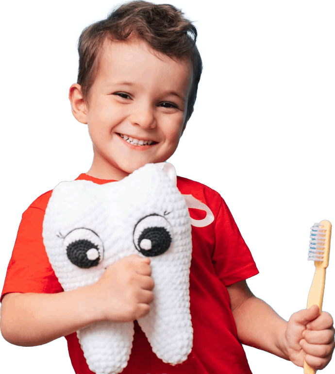 Young boy in a red shirt holding a tooth plushie and toothbrush - Book a pediatric dental appointment in Santa Ana at Bunny Kids Dental