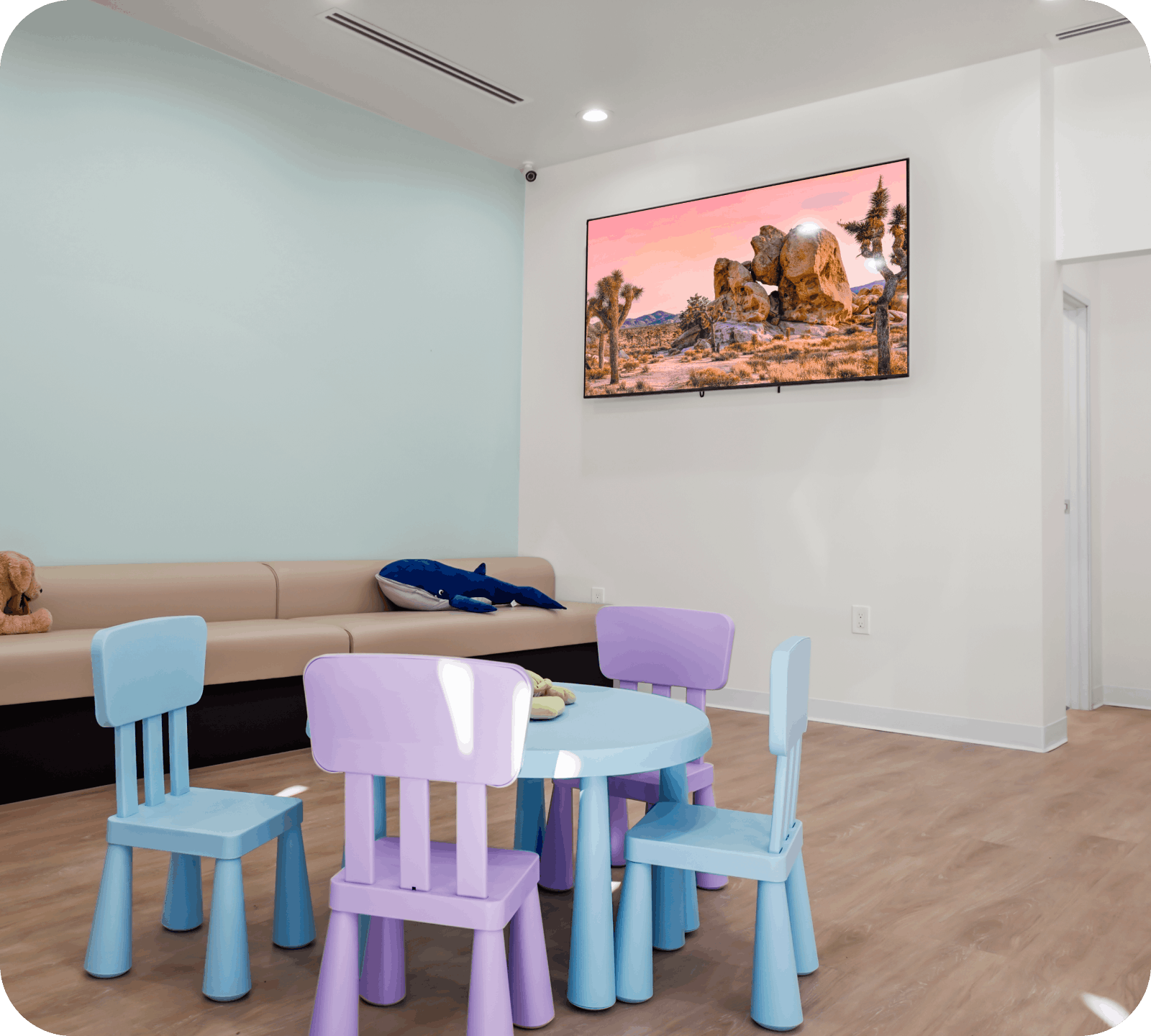 Kid-friendly waiting room with colorful chairs and TV at Bunny Kids Dental
