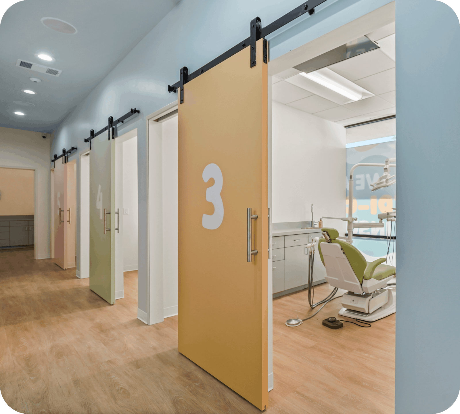Private colorful pediatric dental exam rooms with sliding doors