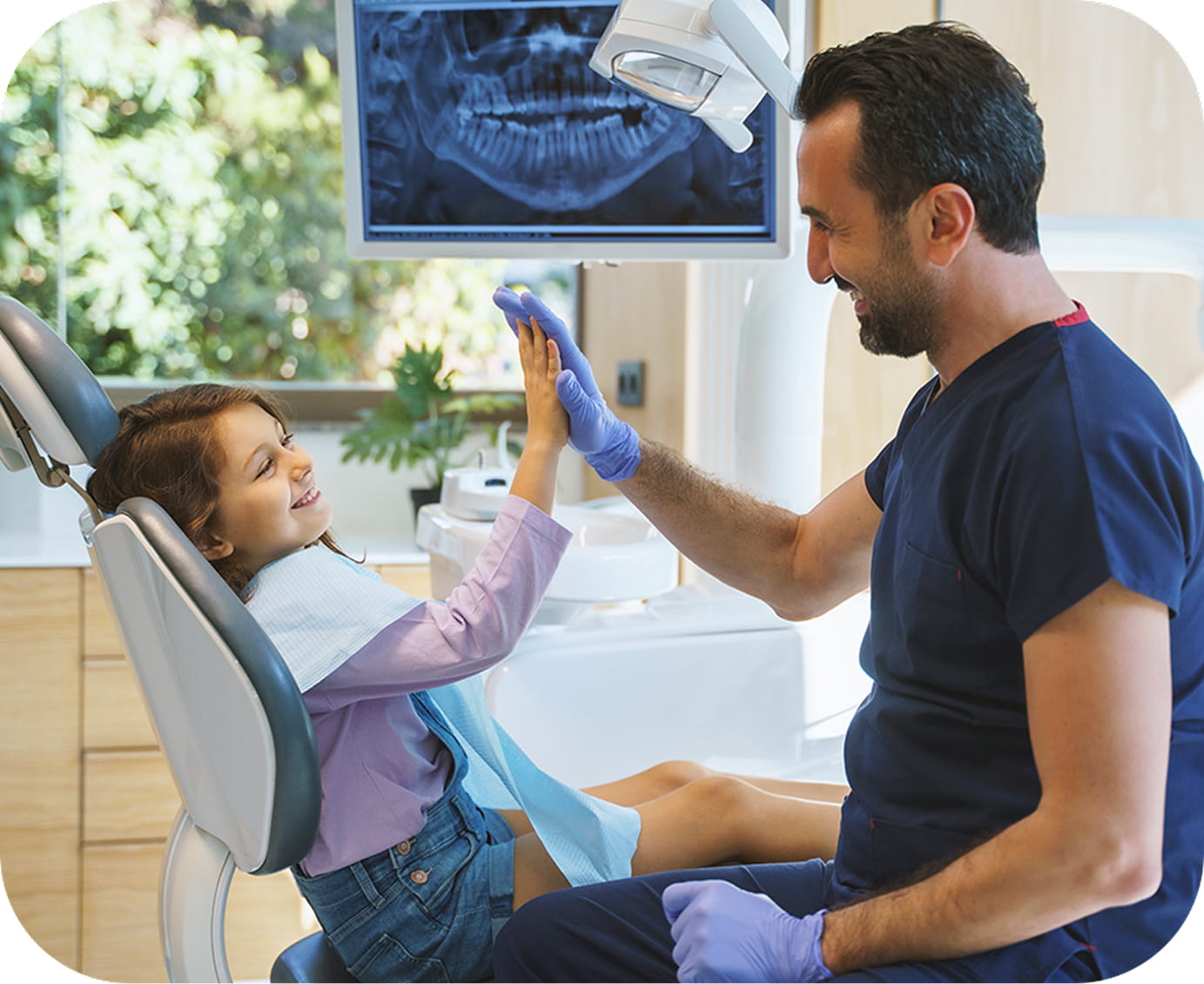 Dentist giving high-five to a young patient during a preventive dental checkup in Santa Ana