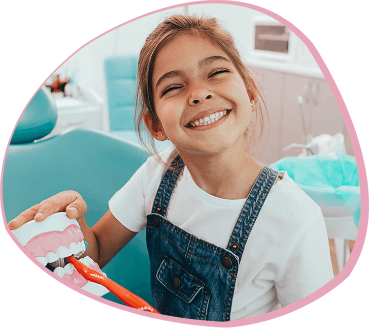 Young girl smiling and learning about dental care at Bunny Kids Dental in Santa Ana